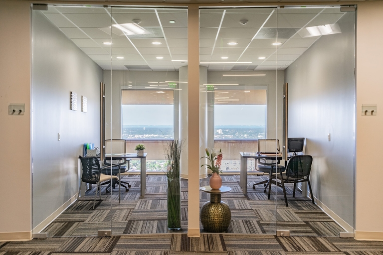 Modern office with glass doors, showcasing sleek design and professional ambiance.